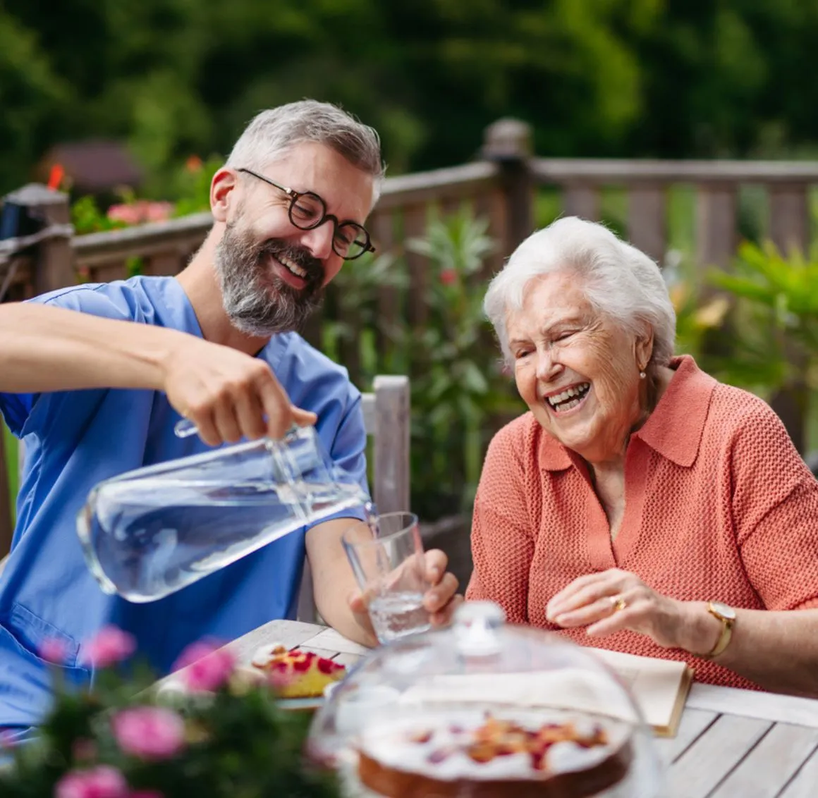 Companion Care in Saratoga caregiver sharing a joyful outdoor moment while serving water to a smiling senior