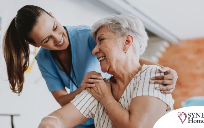 A female caregiver helping an older woman with stroke recovery at home.