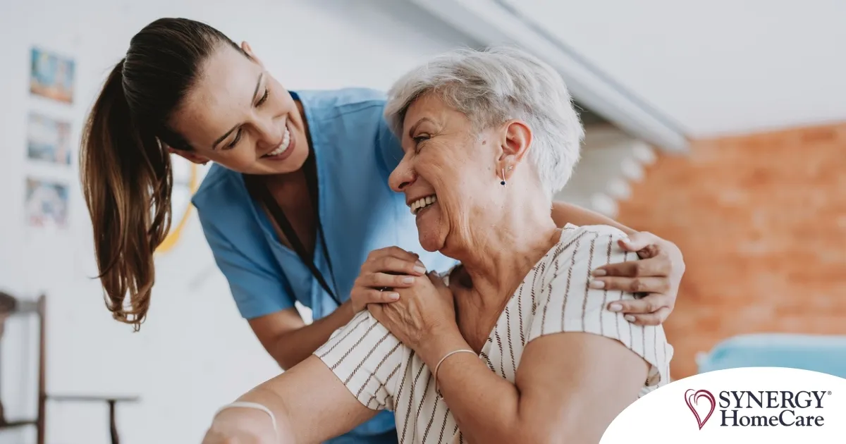 A female caregiver helping an older woman with stroke recovery at home.